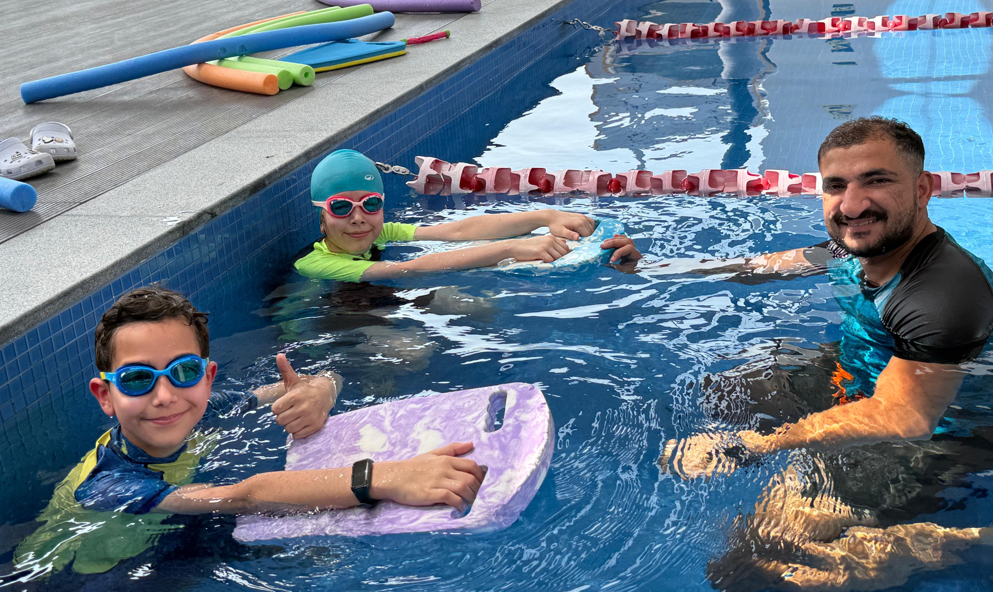 Happy kids enjoying swimming lesson